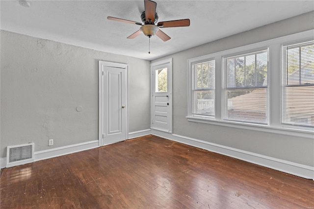 empty room with dark hardwood / wood-style floors and ceiling fan