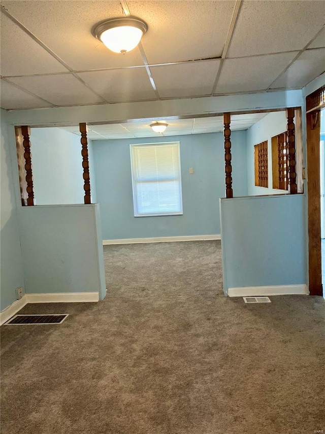 unfurnished room with a drop ceiling and carpet floors