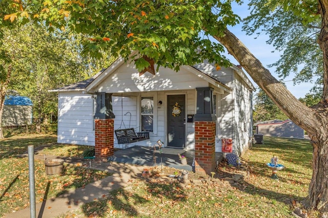 bungalow-style home with a front yard and a porch