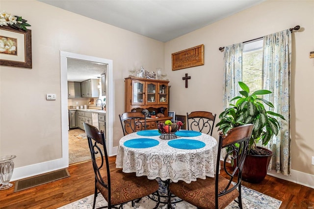 dining space featuring hardwood / wood-style flooring and sink