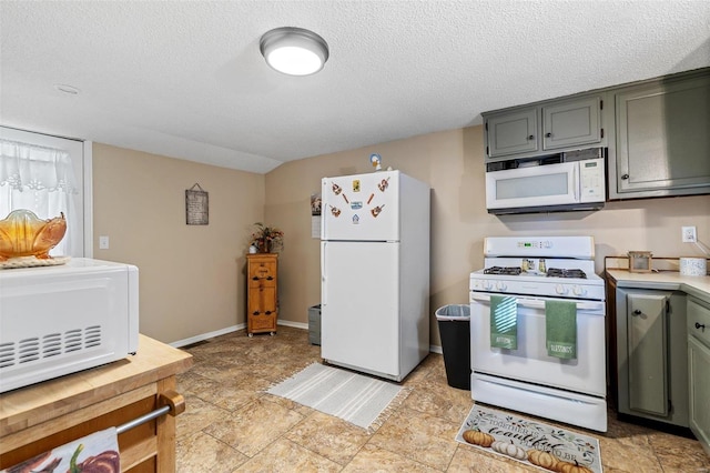 kitchen with a textured ceiling and white appliances