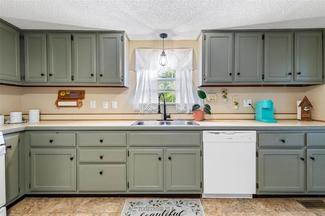 kitchen with white dishwasher, sink, decorative light fixtures, and a textured ceiling