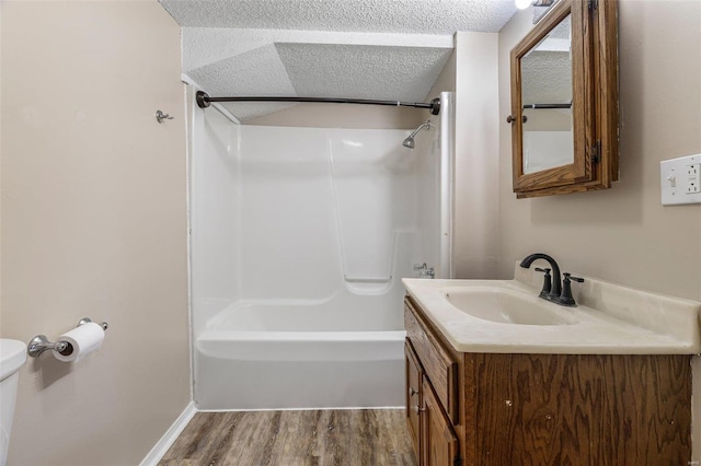 full bathroom featuring wood finished floors, toilet, a textured ceiling, shower / tub combination, and vanity