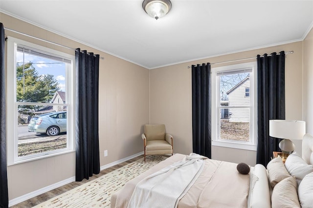 bedroom featuring multiple windows, crown molding, light wood-style flooring, and baseboards