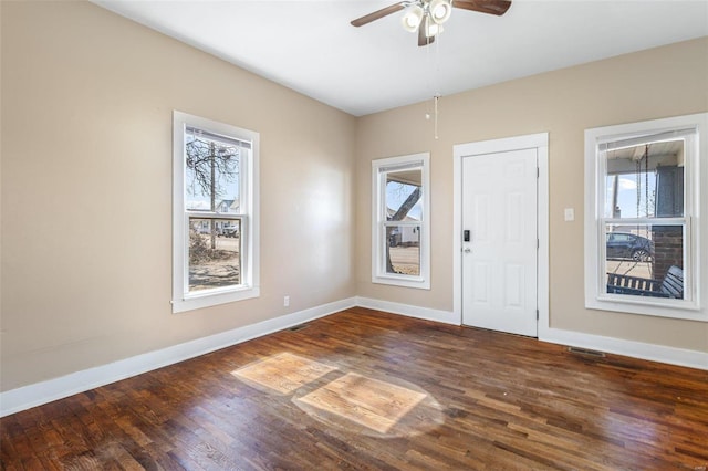 foyer with a ceiling fan, visible vents, baseboards, and wood finished floors