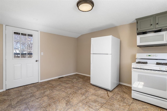 kitchen with white appliances, a textured ceiling, and baseboards