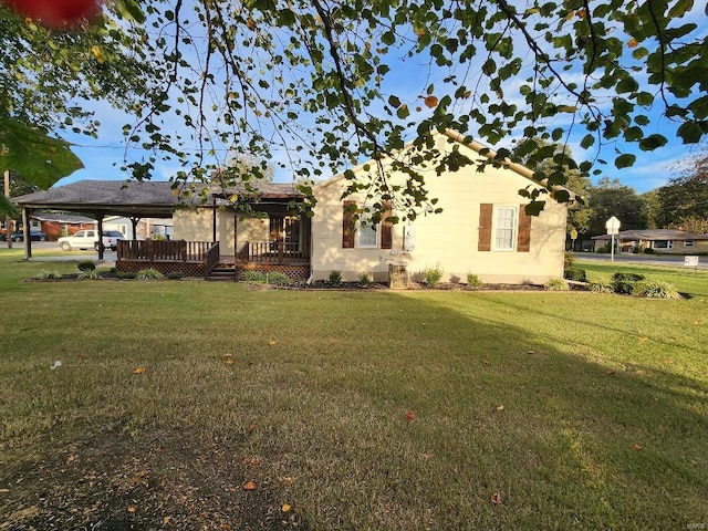 rear view of house featuring a gazebo and a lawn