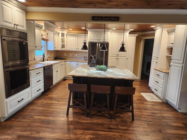 kitchen featuring a kitchen island, dark hardwood / wood-style floors, sink, black appliances, and a kitchen bar