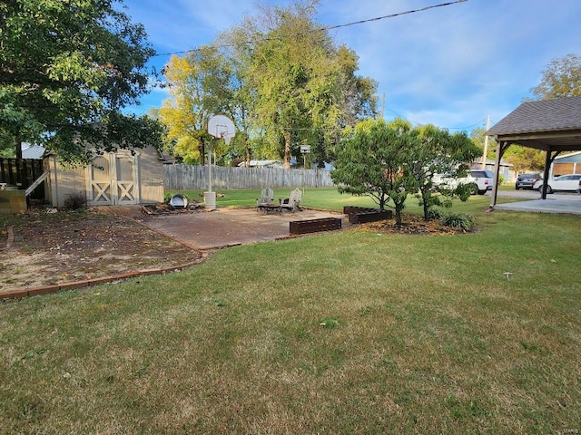 view of yard featuring a storage shed, an outdoor fire pit, and a carport