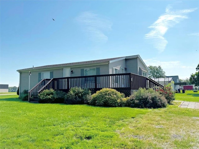 view of front facade featuring a wooden deck and a front yard