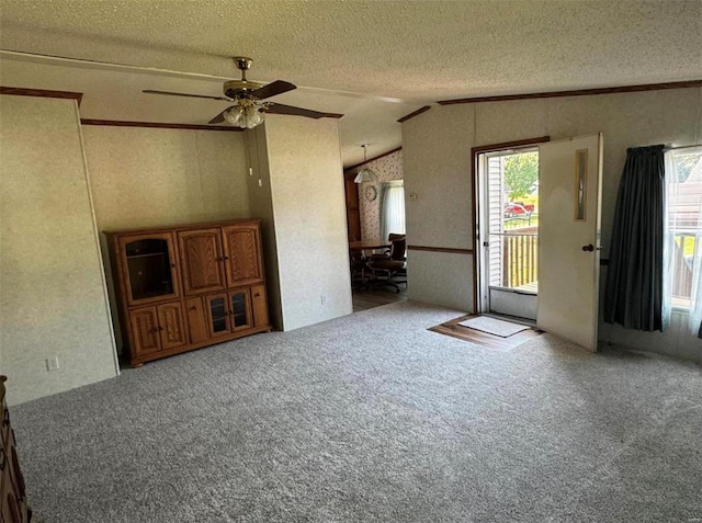 unfurnished living room featuring carpet, a textured ceiling, lofted ceiling, and ceiling fan