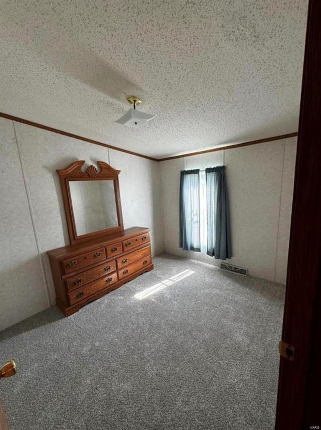 unfurnished bedroom featuring a textured ceiling and carpet