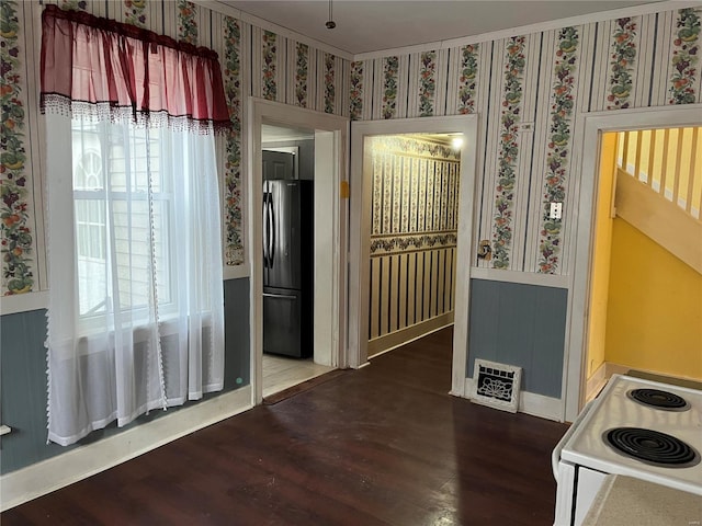 kitchen with white range with electric stovetop, stainless steel fridge, and hardwood / wood-style floors