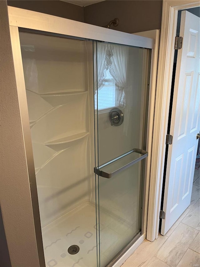 bathroom featuring a shower with shower door