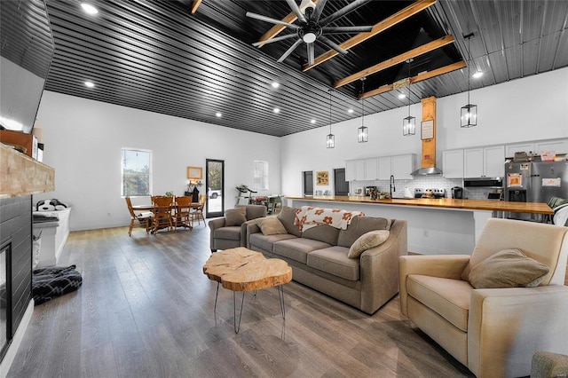 living room featuring ceiling fan, hardwood / wood-style floors, and a high ceiling