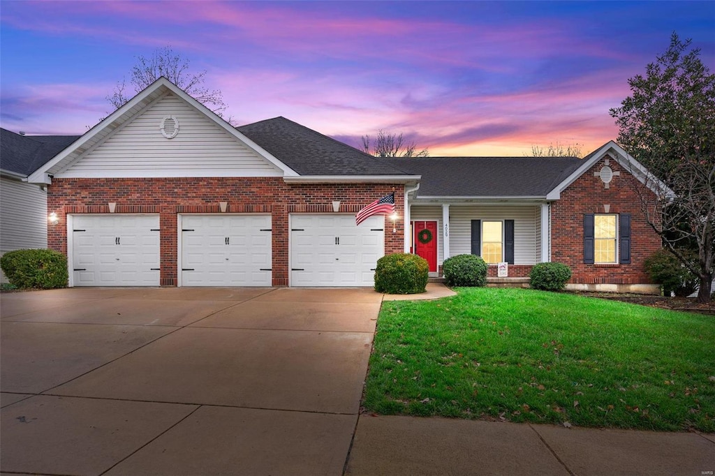 single story home with a lawn and a garage