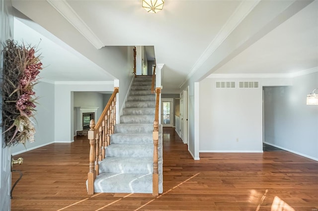 stairway featuring crown molding and hardwood / wood-style flooring