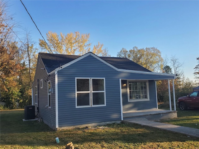 view of side of property featuring a yard and cooling unit