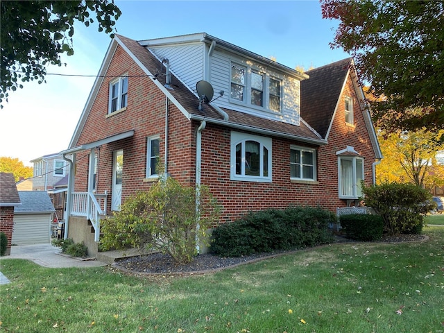 view of side of property featuring a garage and a lawn