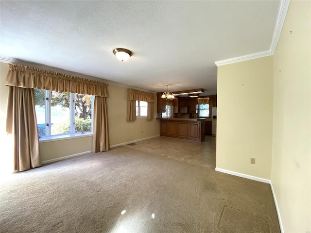 unfurnished living room featuring ornamental molding, a chandelier, a textured ceiling, and carpet