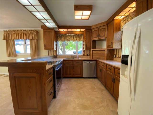 kitchen featuring a healthy amount of sunlight, appliances with stainless steel finishes, sink, and kitchen peninsula