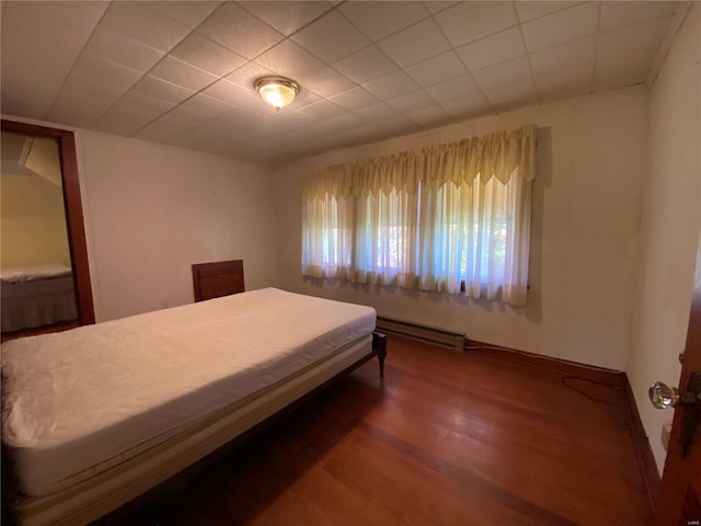 bedroom with wood-type flooring and baseboard heating