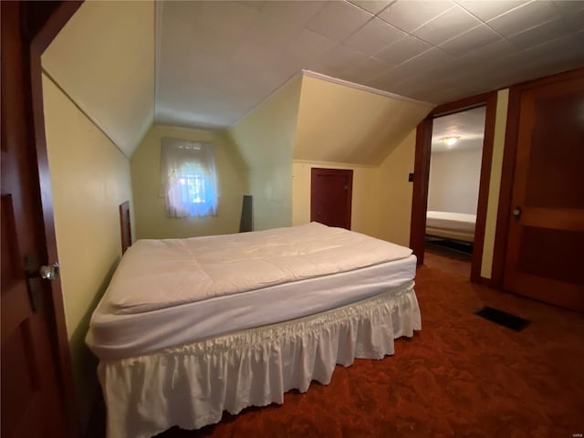 bedroom featuring lofted ceiling and carpet floors