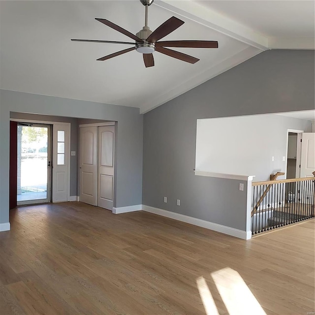 unfurnished living room featuring hardwood / wood-style flooring, lofted ceiling with beams, and ceiling fan