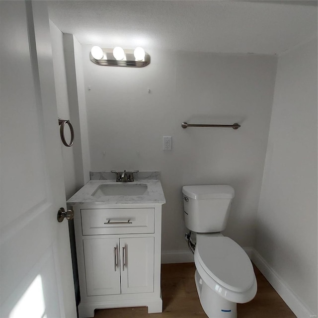 bathroom featuring wood-type flooring, vanity, and toilet