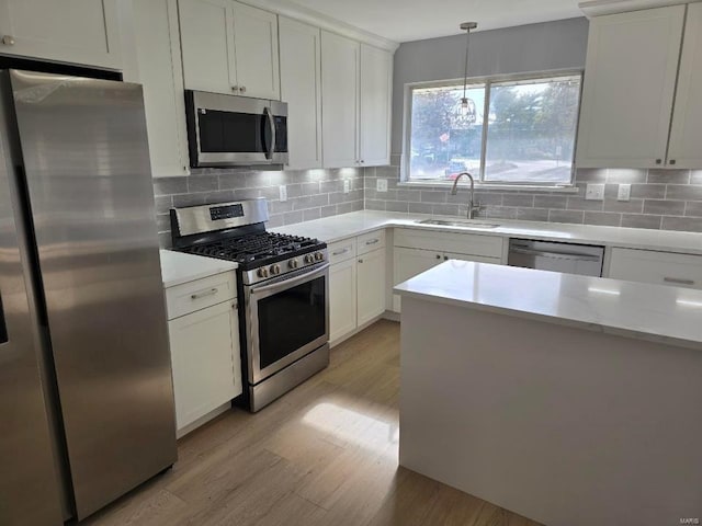 kitchen with decorative backsplash, sink, white cabinets, and stainless steel appliances