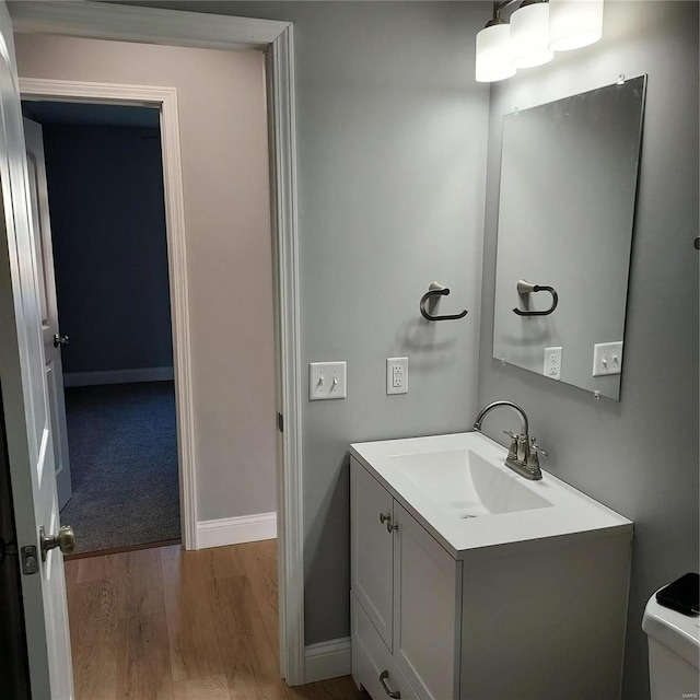 bathroom featuring vanity, hardwood / wood-style flooring, and toilet