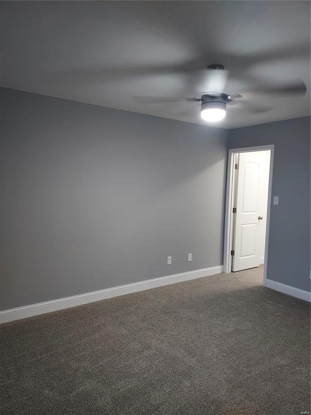 empty room featuring ceiling fan and carpet