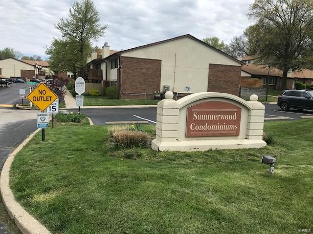 community sign featuring a lawn