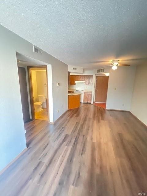 unfurnished living room with light hardwood / wood-style flooring, a textured ceiling, and ceiling fan