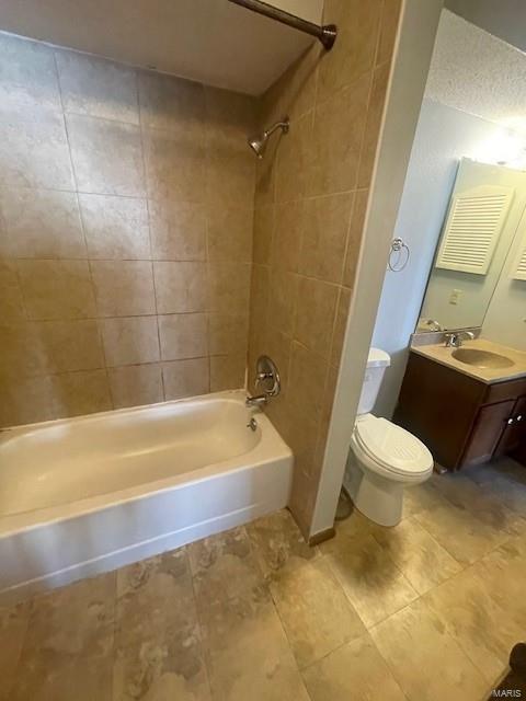 full bathroom with tiled shower / bath, vanity, and toilet