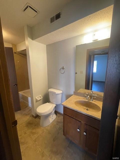 full bathroom with a textured ceiling, toilet, vanity, bathing tub / shower combination, and tile patterned flooring