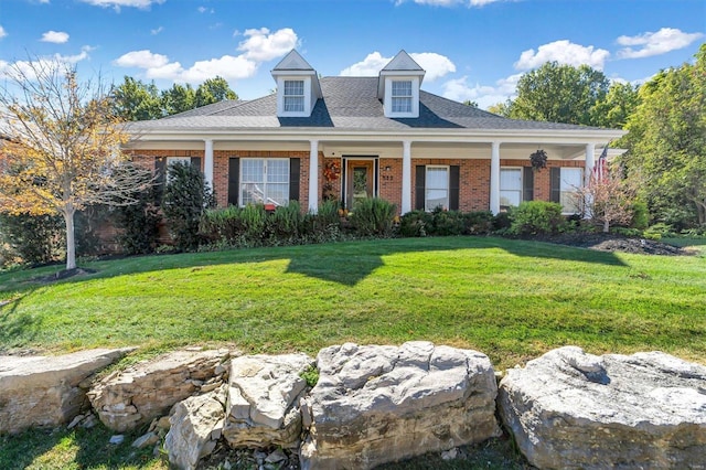 new england style home featuring covered porch and a front yard