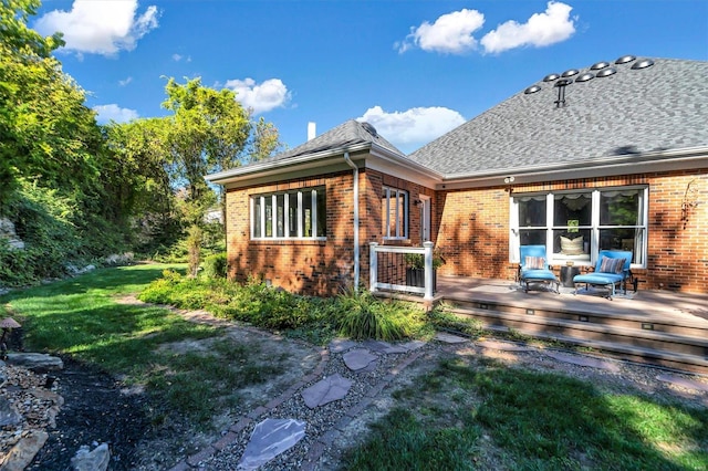 back of property with a wooden deck and a yard