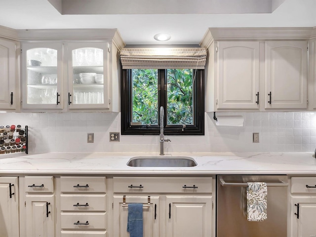 kitchen featuring white cabinetry, tasteful backsplash, sink, and stainless steel dishwasher