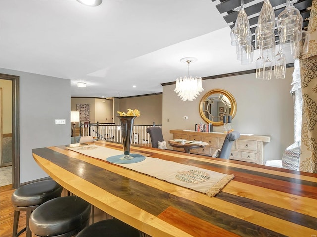 dining space with an inviting chandelier, wood-type flooring, and crown molding