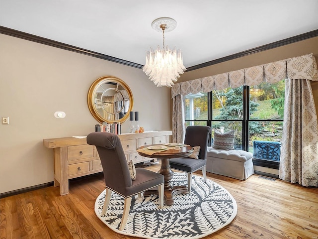 dining room featuring ornamental molding, a chandelier, and light wood-type flooring