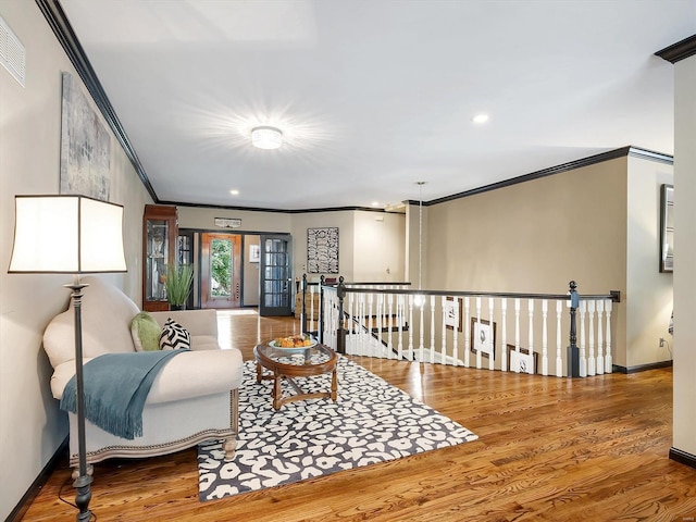 sitting room featuring hardwood / wood-style floors and crown molding