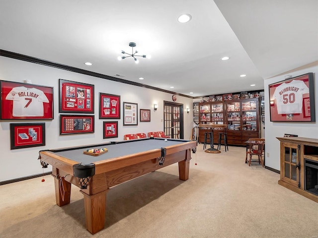 rec room with ornamental molding, a notable chandelier, light colored carpet, and billiards