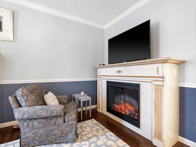 living area with crown molding and dark hardwood / wood-style flooring