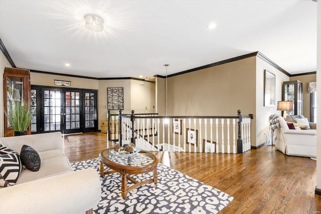 living room with french doors, ornamental molding, and wood-type flooring