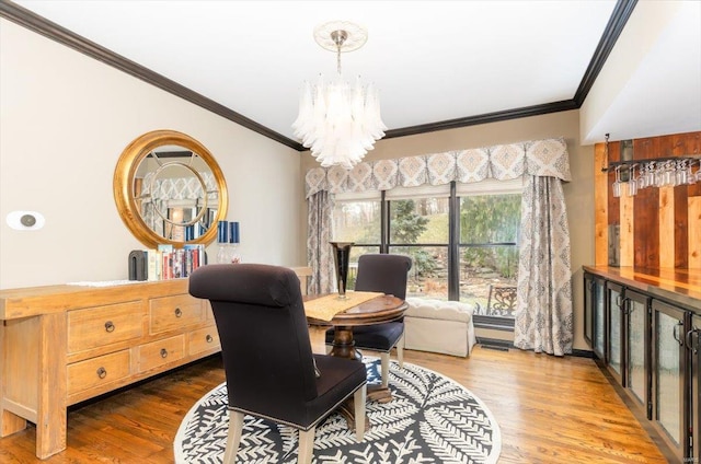 dining room with a notable chandelier, crown molding, and wood-type flooring