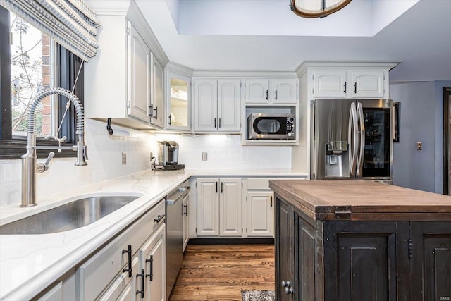 kitchen with dark wood-type flooring, sink, tasteful backsplash, appliances with stainless steel finishes, and white cabinets