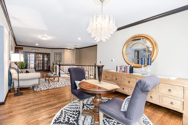 dining room featuring ornamental molding, hardwood / wood-style floors, and a notable chandelier