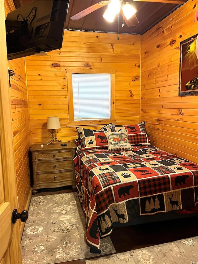 bedroom featuring wood walls and ceiling fan