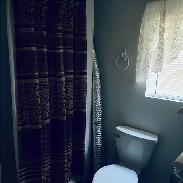 bathroom with curtained shower and toilet